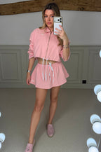 Model wearing the YOGA pink skirt and jacket two piece set, front view