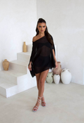 Model wearing the black cape three piece bandeau and shorts set, front view