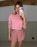Model wearing the YOGA petal pink tracksuit jumper, front view