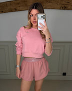 Model wearing the YOGA petal pink tracksuit jumper, front view